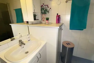 a bathroom with a sink and a mirror at Cozy apartment near city center and nature in Kristiansund