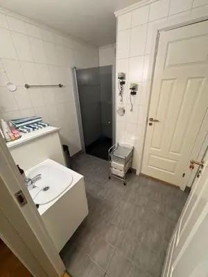 a bathroom with a sink and a white door at Cozy apartment near city center and nature in Kristiansund