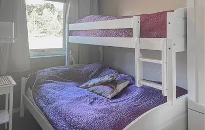 a bedroom with bunk beds with purple sheets and a window at Lovely Apartment In Bjorli With Sauna in Bjorli