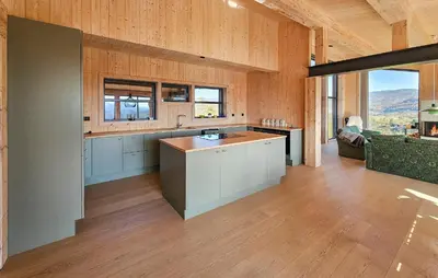 a large kitchen with wooden walls and wooden floors at Nice Home In Edland With Sauna in Nesland