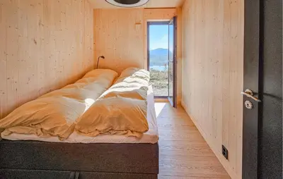 a row of beds in a room with a window at Nice Home In Edland With Sauna in Nesland