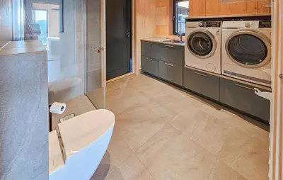 a bathroom with a washing machine and a washer and dryer at Nice Home In Edland With Sauna in Nesland