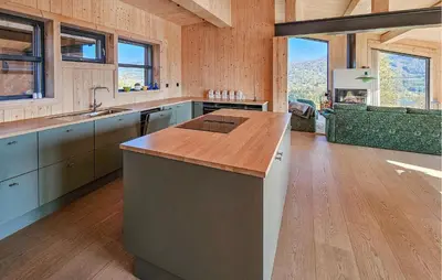 a large kitchen with wooden walls and wooden floors at Nice Home In Edland With Sauna in Nesland