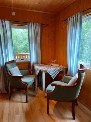a dining room with a table and chairs and windows at Eidsdal Camping og Feriehus in Eidsdal