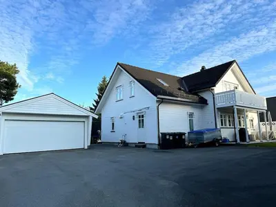 a white house with a garage and a driveway at Stor enebolig i Trondheim in Trondheim