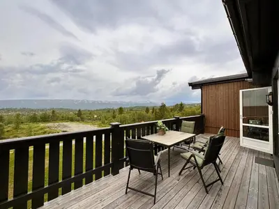 a wooden deck with a table and chairs on it at Ideal Family Retreat With 3 Bedrooms in Beitostøl