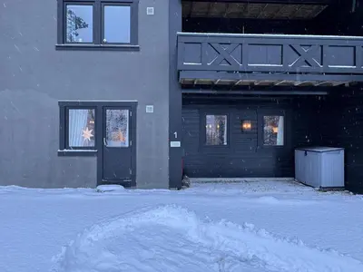 a house with a door in the snow at Spacious apartment near Hemsedal ski resort in Hemsedal