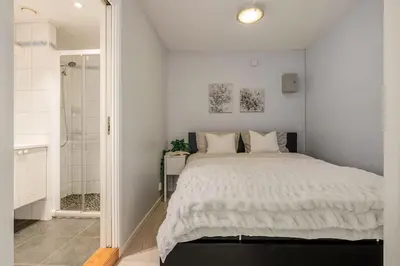 a white bedroom with a bed and a shower at Flat in Bergen house with outstanding roof terrace in Bergen
