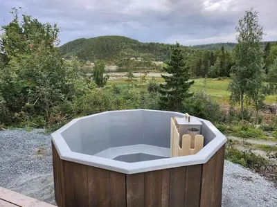 a bath tub sitting on top of a field at Nyoppført hytte med mulighet til å leie badestamp in Levanger