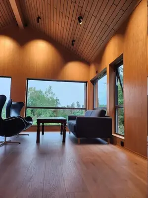a living room with two chairs and a table at Nyoppført hytte med mulighet til å leie badestamp in Levanger