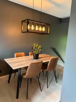 a dining room table with chairs and a potted plant at Delikat og moderne rekkehus in Lillehammer