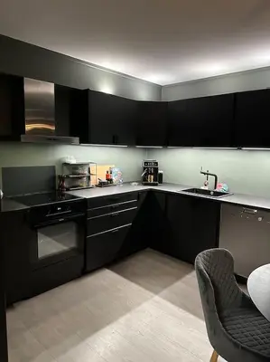 a kitchen with black cabinets and a sink at Delikat og moderne rekkehus in Lillehammer