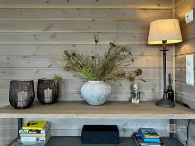 a vase with flowers in it on a shelf at High standard cabin at Sjusjøen sauna, hot tub & ski trails right outside in Ringsaker