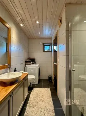 a bathroom with two sinks and a glass shower at High standard cabin at Sjusjøen sauna, hot tub & ski trails right outside in Ringsaker