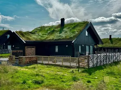 a black house with a grassy hill on top of it at High standard cabin at Sjusjøen sauna, hot tub & ski trails right outside in Ringsaker