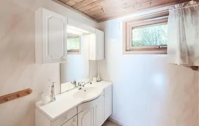 a white bathroom with a sink and a window at 3 Bedroom Amazing Home In Reksteren in Haukafer