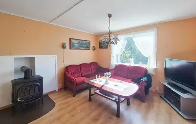 a living room with red couches and a table and a television at 3 Bedroom Amazing Home In Reksteren in Haukafer