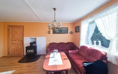 a living room with a red couch and a table at 3 Bedroom Amazing Home In Reksteren in Haukafer