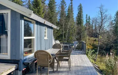 a deck with a table and chairs on a house at 3 Bedroom Nice Home In Tuddal in Tuddal