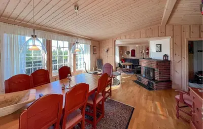 a dining room with a wooden table and chairs at Stunning Home In Sjusjøen With Sauna in Sjusjøen