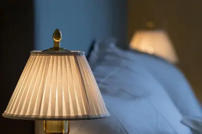 a lamp that is next to a bed at Jervell 4 Bnb in Ålesund