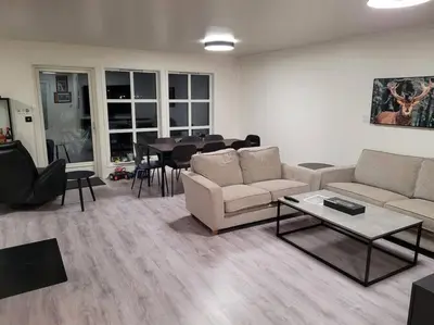 a living room with couches and a table and a dining room at Hareid in Hareid