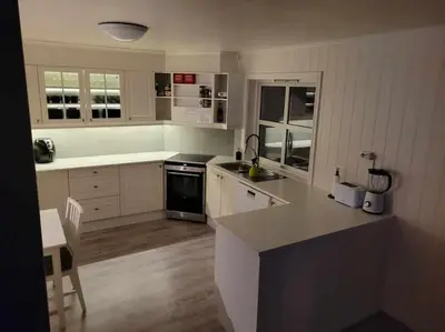 a kitchen with white cabinets and a counter top at Hareid in Hareid