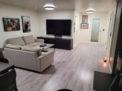 a living room with a couch and a flat screen tv at Hareid in Hareid