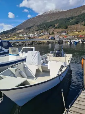 a boat is docked at a dock in the water at Hareid in Hareid