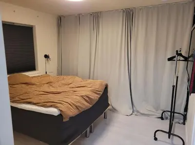 a bedroom with a bed in a room with curtains at Hareid in Hareid