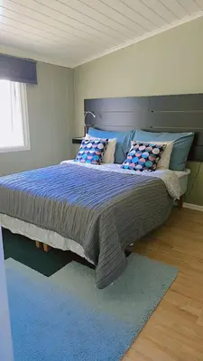 a bedroom with a large bed with a blue comforter at Room In Handsome Haven House in Gjøvik