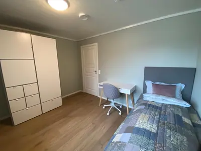 a bedroom with a bed and a desk in it at Leilighet på Hardbakke in Lia