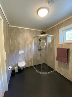 a bathroom with a shower and a toilet at Leilighet på Hardbakke in Lia