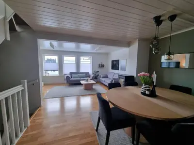 a living room with a table and a couch at Koselig familiebolig Granåsen in Trondheim