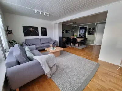 a living room with a blue couch and a table at Koselig familiebolig Granåsen in Trondheim