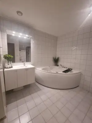 a large white bathroom with a tub and a sink at Koselig familiebolig Granåsen in Trondheim