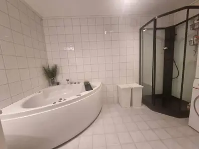 a white bathroom with a tub and a toilet at Koselig familiebolig Granåsen in Trondheim