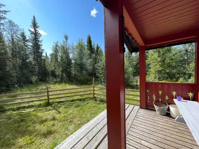 a porch of a red house with a fence at Granbu by Norgesbooking - cozy cabin at Golsfjellet in Ulnes