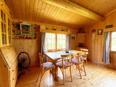 a dining room with a wooden table and chairs at Granbu by Norgesbooking - cozy cabin at Golsfjellet in Ulnes