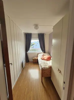 a small bedroom with a bed and a window at Cozy Home with Sauna, river views and 10 min from Hafjell and Lillehammer in Fåberg