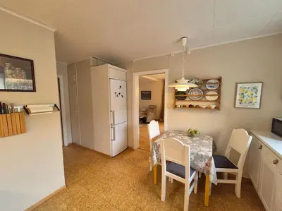 a kitchen and dining room with a table and a refrigerator at Cozy Home with Sauna, river views and 10 min from Hafjell and Lillehammer in Fåberg