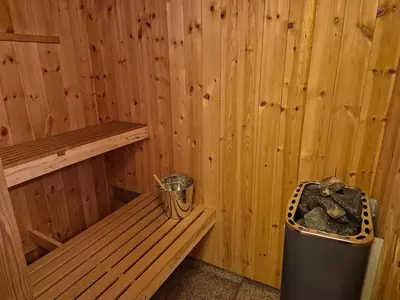 a sauna with a bench and a trash can at Cozy Home with Sauna, river views and 10 min from Hafjell and Lillehammer in Fåberg