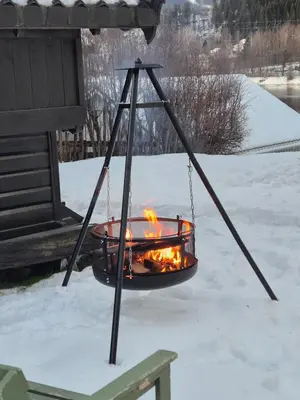 a fire pit with flames in it in the snow at Cozy Home with Sauna, river views and 10 min from Hafjell and Lillehammer in Fåberg