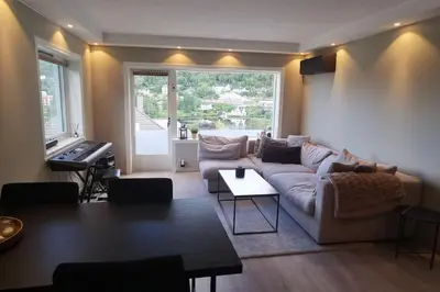 a living room with a couch and a piano at Koselig leilighet nær sentrum in Laksevag