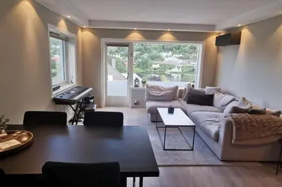 a living room with a couch and a table at Koselig leilighet nær sentrum in Laksevag