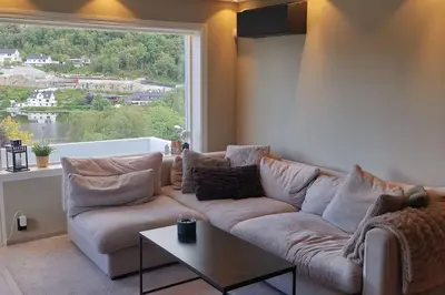 a living room with a couch and a large window at Koselig leilighet nær sentrum in Laksevag