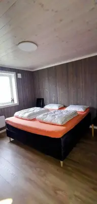 a large bed in a bedroom with a wooden wall at Fantastisk feriehus på Tretten, Hafjell in Tretten