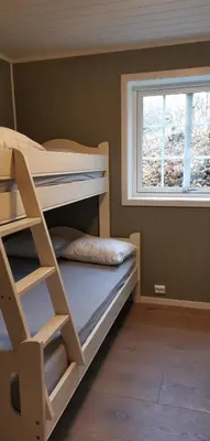 a bunk bed in a room with a window at Fantastisk feriehus på Tretten, Hafjell in Tretten
