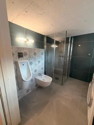 a bathroom with a urinal and a sink and a toilet at Fantastisk feriehus på Tretten, Hafjell in Tretten