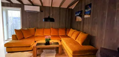 a living room with an orange couch and a table at Fantastisk feriehus på Tretten, Hafjell in Tretten